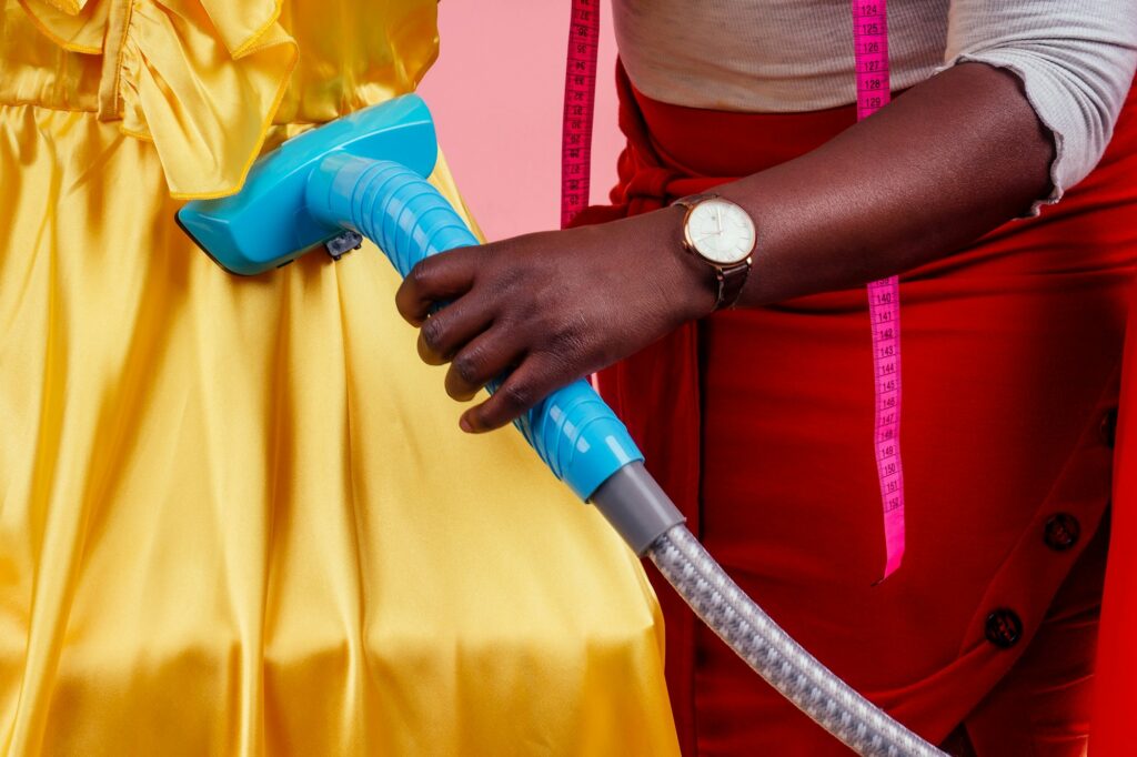 african american tailor dressmaker holding vapor device hot steam generator